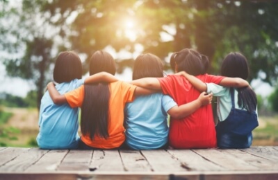 daniel-schlegel-group-kids-friends-arm-around-sitting-together